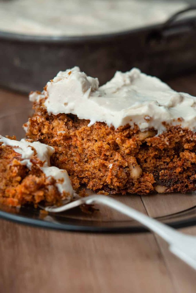 slice of carrot cake on a plate with cream cheese frosting