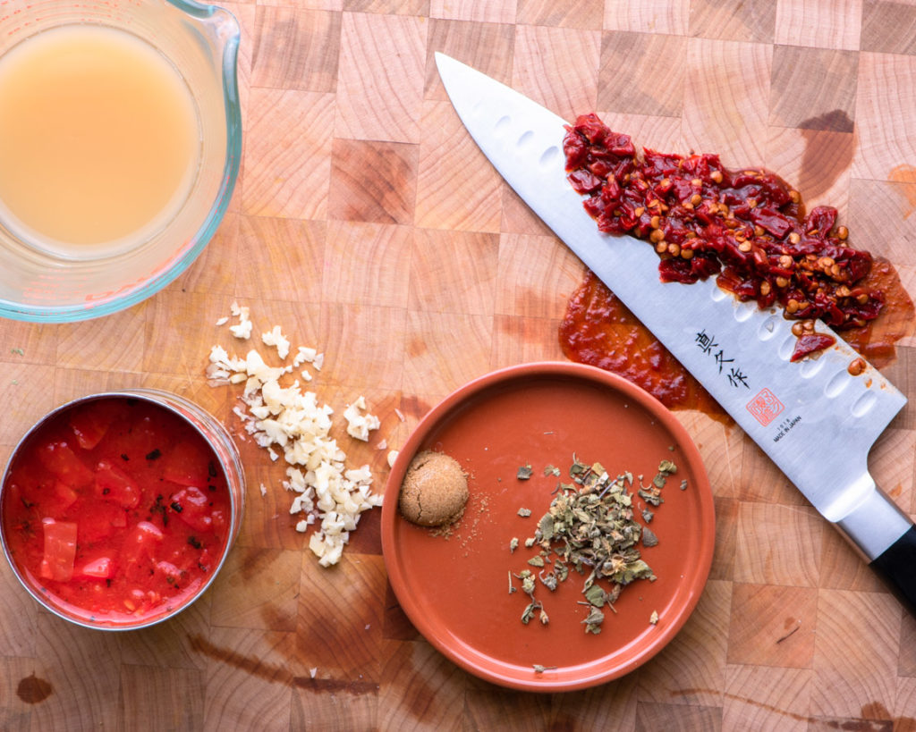 chicken tinga ingredients: chicken stock, chipotle peppers, fire roasted tomatoes, oregano, cumin, and garlic