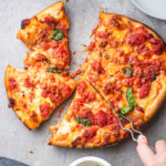 deep dish pizza with sausage and Italian peppers and basil