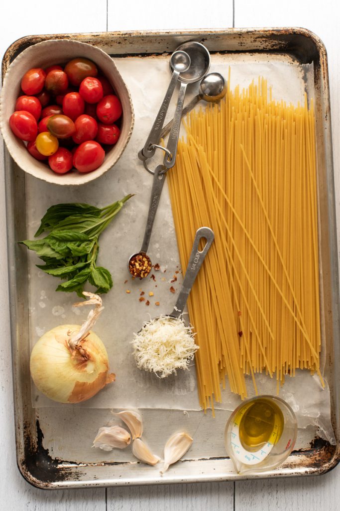 spaghetti noodles cherry tomatoes garlic onion and red pepper flakes