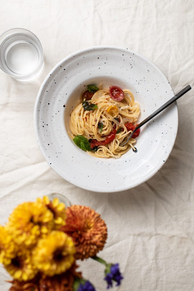 spaghetti dinner with cherry tomatoes and fresh basil